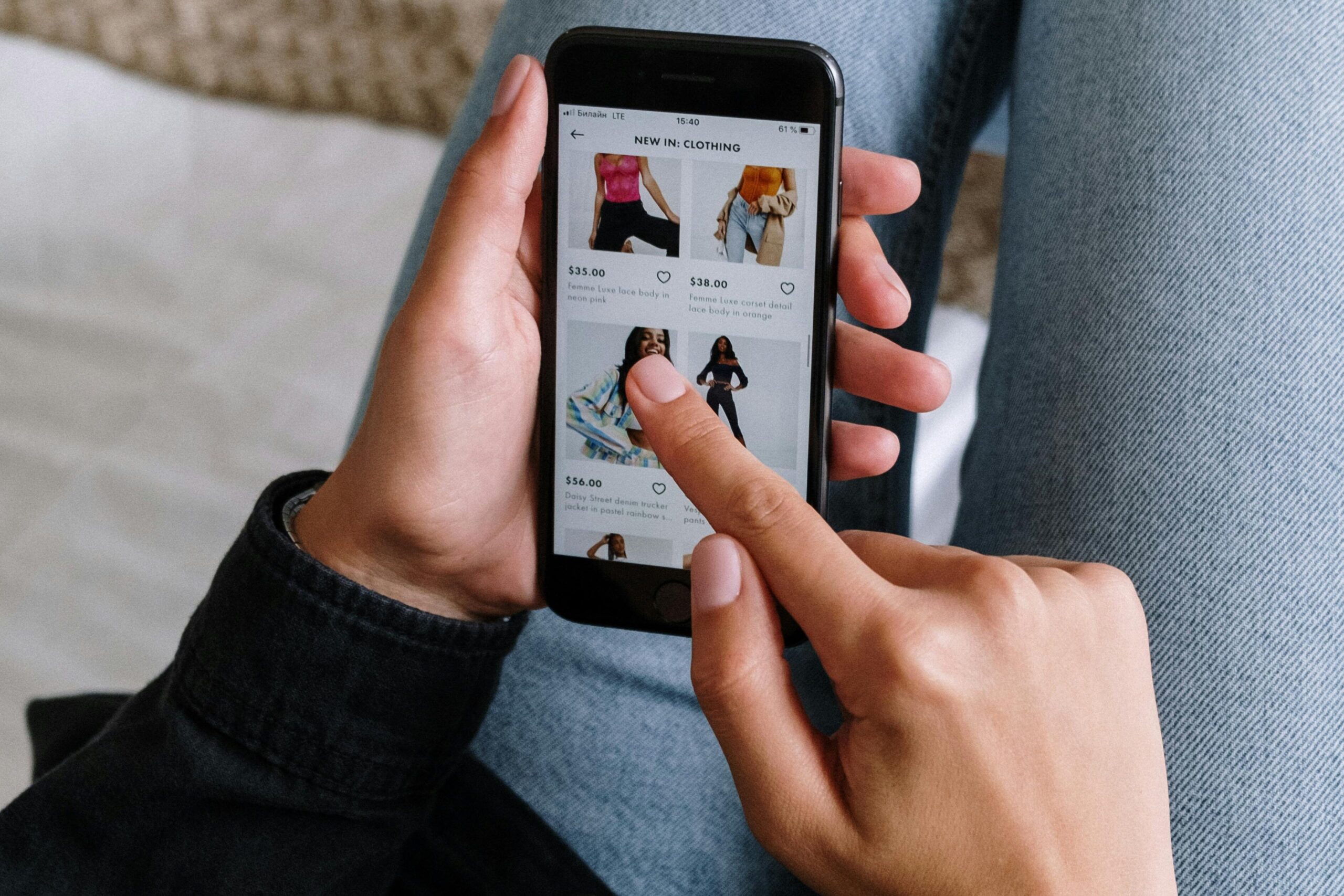 Close-up of a woman shopping online on a smartphone while relaxing at home.